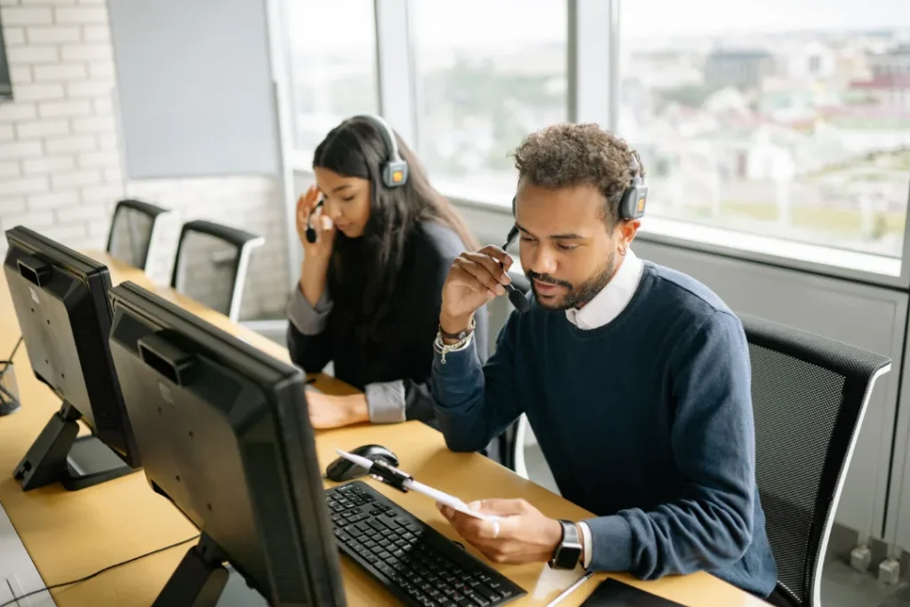 team of computer technicians sitting at desk talking on the phone